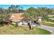 Aerial view of a well-maintained home with a tile roof, mature trees, and attractive landscaping at 5718 Garden Lakes Palm, Bradenton, FL 34203