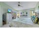 Bright main bedroom with tropical themed bedding, ceiling fan, dresser, and sliding glass doors to the lanai at 5718 Garden Lakes Palm, Bradenton, FL 34203