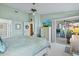 Spacious main bedroom with a king-size bed, a dresser with a tv, and glass doors leading to the lanai at 5718 Garden Lakes Palm, Bradenton, FL 34203