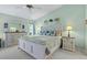 Airy main bedroom with a white wood bed frame, coastal themed bedding, and matching nightstands at 5718 Garden Lakes Palm, Bradenton, FL 34203