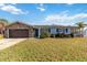 Well-maintained single-story home with stone accents, blue shutters, and a lush front yard at 6001 Firefly Ln, Apollo Beach, FL 33572