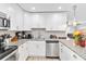 Modern kitchen with stainless steel appliances, granite counters, and white cabinets at 6001 Firefly Ln, Apollo Beach, FL 33572