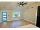 Open-concept living room featuring a vaulted ceiling, a modern ceiling fan, large windows, and light, wood-look flooring at 6226 21St N Ave, St Petersburg, FL 33710