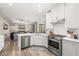 Open-concept kitchen showcasing white cabinets, stainless steel appliances, and seamless flow to living area at 6373 Royal Tern Cir, Lakewood Ranch, FL 34202