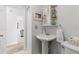 Bathroom with a pedestal sink, decorative mirror, and a toilet at 6796 Gasparilla Pines Blvd # 45, Englewood, FL 34224