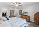 Bedroom features a cozy queen size bed and a wooden dresser topped with a flat screen TV at 6796 Gasparilla Pines Blvd # 45, Englewood, FL 34224