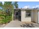 Home's charming entrance featuring a screened-in porch, landscaping, and unit number 45 at 6796 Gasparilla Pines Blvd # 45, Englewood, FL 34224