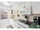 Well-lit kitchen with white cabinets, green countertops, stainless steel appliances, and a sunny window at 6796 Gasparilla Pines Blvd # 45, Englewood, FL 34224