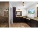 Bathroom with granite counters, dark wood cabinetry, and a tiled shower at 6807 46Th E Ter, Bradenton, FL 34203