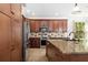 Well-lit kitchen features granite counters, stainless steel appliances, and wooden cabinetry at 6807 46Th E Ter, Bradenton, FL 34203