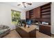 Well-lit home office with custom built-in shelves, granite countertops, and a peaceful window view at 6807 46Th E Ter, Bradenton, FL 34203