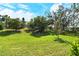 Lush green backyard with mature trees under a bright blue sky at 7212 Ketch Pl, Bradenton, FL 34212