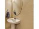 Bathroom featuring a pedestal sink, oval mirror, and textured wall at 7212 Ketch Pl, Bradenton, FL 34212