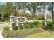 Stone monument sign at Regatta Landing surrounded by green landscaping and trees at 7212 Ketch Pl, Bradenton, FL 34212