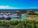 Scenic aerial view of a school campus with sports fields, buildings, and a distant ocean view at 779 Fordingbridge Way, Osprey, FL 34229