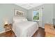 Cozy bedroom with wood floors, a queen-sized bed, neutral paint, and natural light from the window at 779 Fordingbridge Way, Osprey, FL 34229