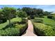 Serene landscaped yard with winding brick pathway, lush greenery, bushes, and manicured lawn at 779 Fordingbridge Way, Osprey, FL 34229