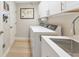 Bright laundry room with white cabinetry, modern appliances, and convenient utility sink at 779 Fordingbridge Way, Osprey, FL 34229