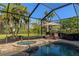 Private backyard oasis with a pool, hot tub, lounge chairs, and lush tropical landscaping at 779 Fordingbridge Way, Osprey, FL 34229