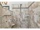 A close-up of a shower, featuring neutral tile, a shower head, and corner shelves for storage at 779 Fordingbridge Way, Osprey, FL 34229