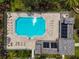 Aerial view of a community swimming pool featuring brick pool deck, lounge chairs, and a covered cabana area at 779 Fordingbridge Way, Osprey, FL 34229