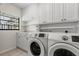 Bright laundry room with washer, dryer, and white cabinets at 7805 Capwood Ave, Temple Terrace, FL 33637