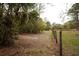 A view of the backyard perimeter that includes a fence line and native landscaping at 8570 Tropicaire Blvd, North Port, FL 34291