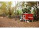 View of a well-maintained chicken coop with a secure enclosure in a wooded setting at 8570 Tropicaire Blvd, North Port, FL 34291