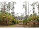 Exterior view of the home nestled among palm trees and lush greenery at 8570 Tropicaire Blvd, North Port, FL 34291