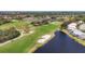 Beautiful aerial view of the community golf course with a tranquil pond and scenic greenery at 8727 Grey Oaks Ave, Sarasota, FL 34238