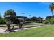 Bocce ball court with lounge chairs and covered area surrounded by lush landscaping at 8727 Grey Oaks Ave, Sarasota, FL 34238