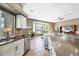 Open kitchen with stainless steel appliances, center island with bar seating and view of the living room at 8727 Grey Oaks Ave, Sarasota, FL 34238