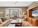 Living area with beautiful bay windows providing natural light, plush seating, and custom media center at 8727 Grey Oaks Ave, Sarasota, FL 34238