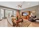 Comfortable living room featuring large bay window, ceiling fan, and custom built-in entertainment center at 8727 Grey Oaks Ave, Sarasota, FL 34238