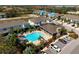 Aerial view of the community pool area surrounded by tropical landscaping, parking, and residential homes at 8737 Daydream St, Sarasota, FL 34238