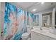 Bright bathroom with neutral wall paint, blue shower curtain, toilet and sink at 8849 Etera Dr, Sarasota, FL 34238