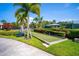 Beautiful bocce ball court surrounded by green grass, palms, and colorful flowers at 8849 Etera Dr, Sarasota, FL 34238