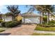 Charming home featuring a white garage door, tile roof, brick driveway, and beautifully manicured landscaping at 8849 Etera Dr, Sarasota, FL 34238