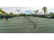 Active tennis court with players and shaded seating area, set in lush greenery at 8849 Etera Dr, Sarasota, FL 34238