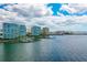 Expansive aerial view showcasing waterfront condos with access to bay and marina, under bright cloudy skies at 888 Blvd Of The Arts # 1608, Sarasota, FL 34236