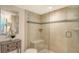 Bathroom with shower and glass door, with neutral tone tiles and decorative accent tiles at 888 Blvd Of The Arts # 1608, Sarasota, FL 34236