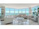 Bright living room with floor-to-ceiling windows offering panoramic water views with bright white furniture at 888 Blvd Of The Arts # 1608, Sarasota, FL 34236