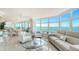 Bright living room with floor-to-ceiling windows offering panoramic water views and an attached dining area at 888 Blvd Of The Arts # 1608, Sarasota, FL 34236