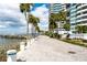 Scenic waterfront pathway bordered by palm trees, leading to boat docks, for a serene residential experience at 888 Blvd Of The Arts # 1608, Sarasota, FL 34236