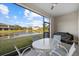 Screened patio with table and chairs and pond view at 8995 Milestone Dr, Sarasota, FL 34238