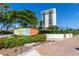 Exterior view showcasing a tall condominium building and Siesta Key Village signage at 951 Contento St., Siesta Key, FL 34242