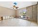 Bright living room featuring tile floors, ceiling fan, and a sliding glass door that leads to a waterfront view at 951 Contento St., Siesta Key, FL 34242