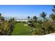 Oceanfront property with expansive lawn, tropical landscaping, and patio at 1067 Westway Dr, Sarasota, FL 34236