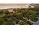 Luxury beachfront home with tropical landscaping at sunset at 1067 Westway Dr, Sarasota, FL 34236