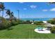 Spacious beachfront yard with surfboard racks and thatch umbrella at 1067 Westway Dr, Sarasota, FL 34236